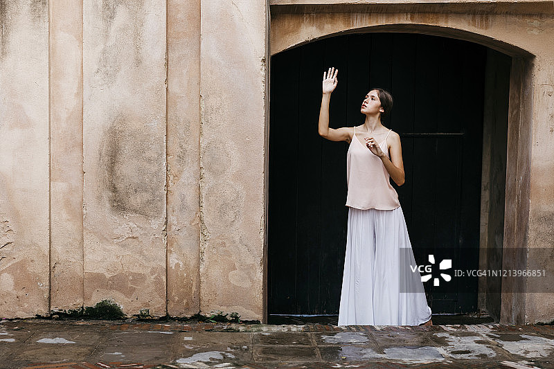 少女站在入口前举起手图片素材