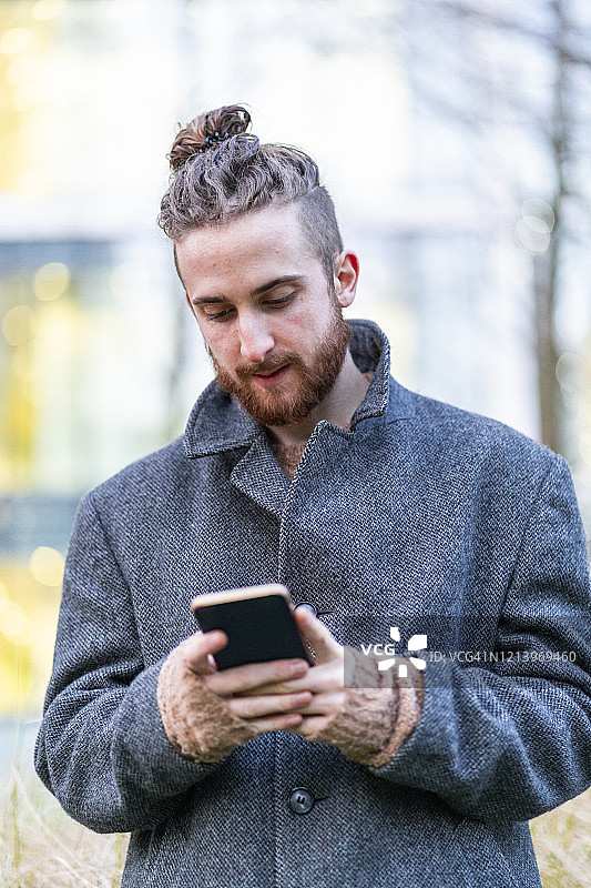 在城市里使用手机的年轻男人图片素材