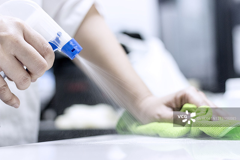 清洁概念：用酒精喷雾清洁桌子图片素材