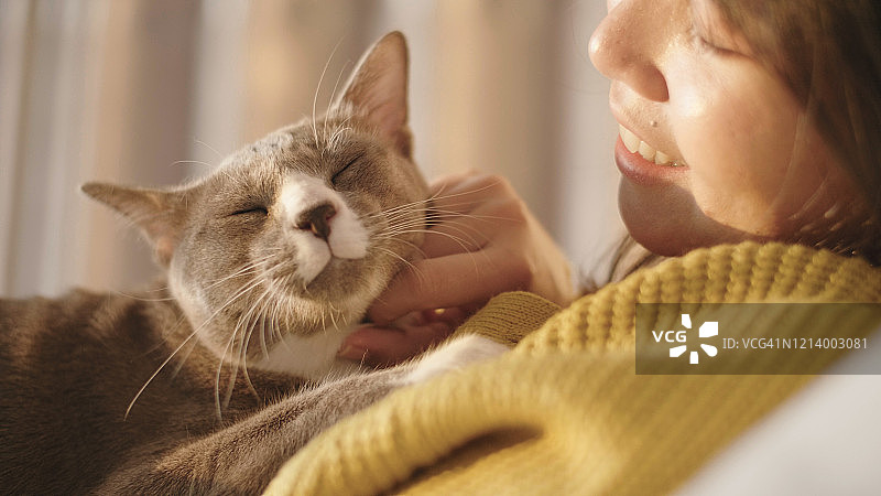在卧室白色床上抚摸宠物的女子肖像图片素材