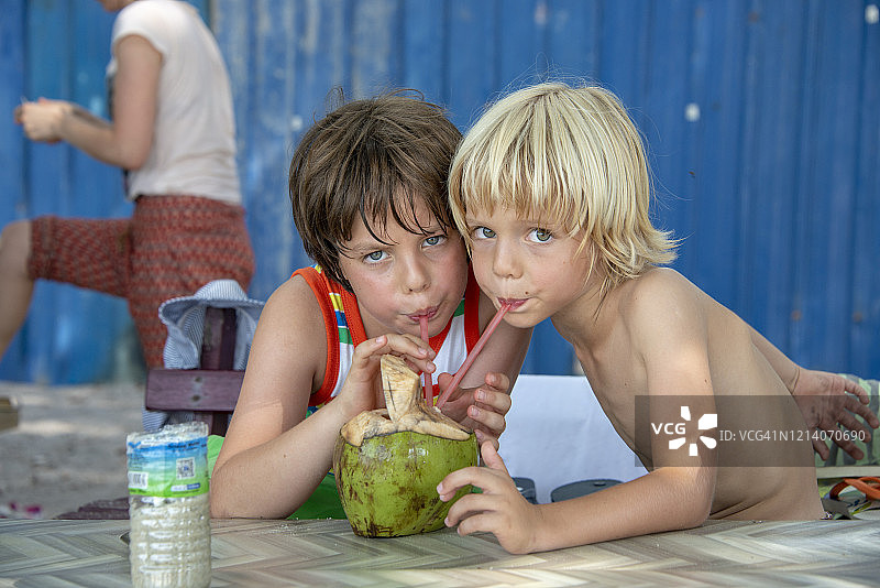快乐的兄弟在马来西亚猴子海滩喝美味的椰子图片素材