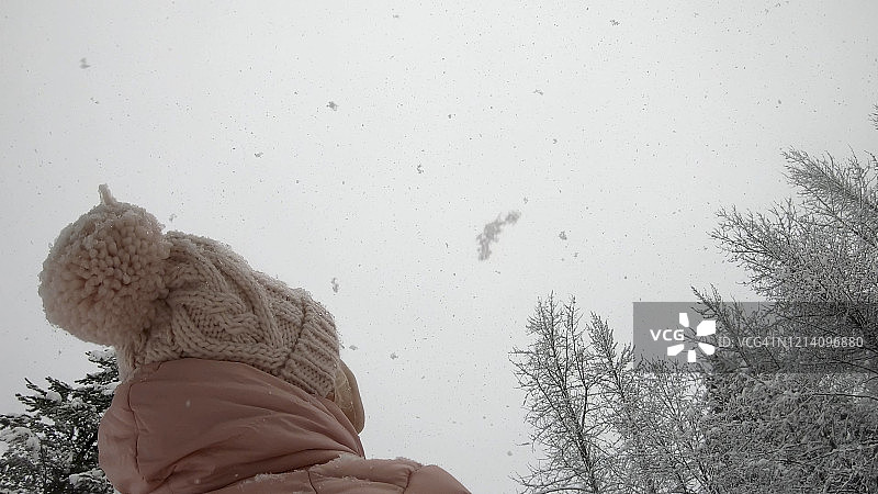 女性徒步者穿过白雪皑皑的森林图片素材