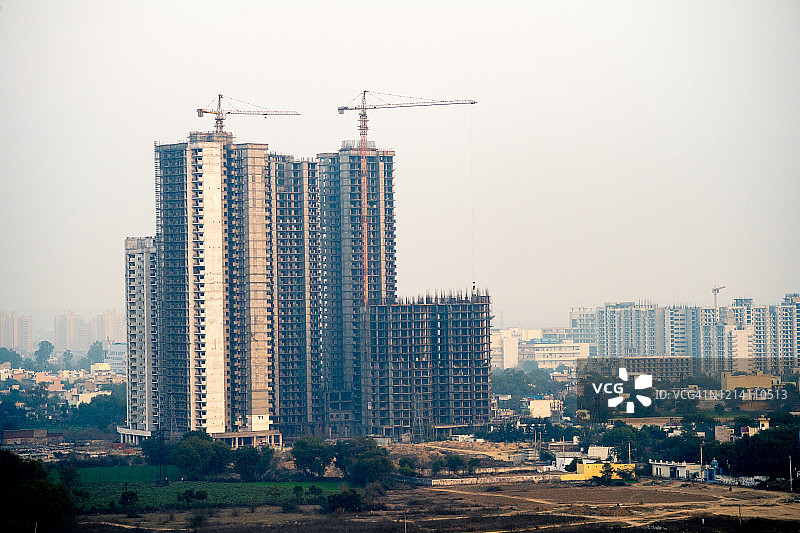 古尔冈在建建筑的航拍，屋顶上有起重机，周围是空旷的场地图片素材