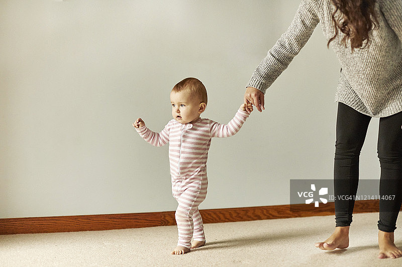 宝宝牵着年轻人的手，迈出第一步图片素材