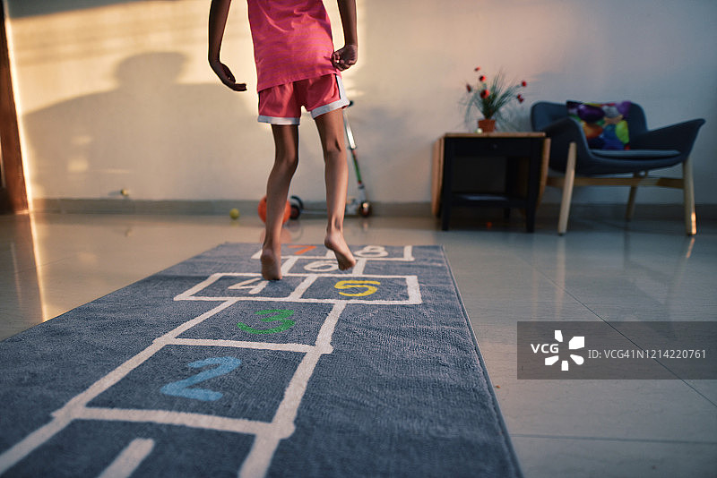 在毯子上玩跳房子的女孩图片素材