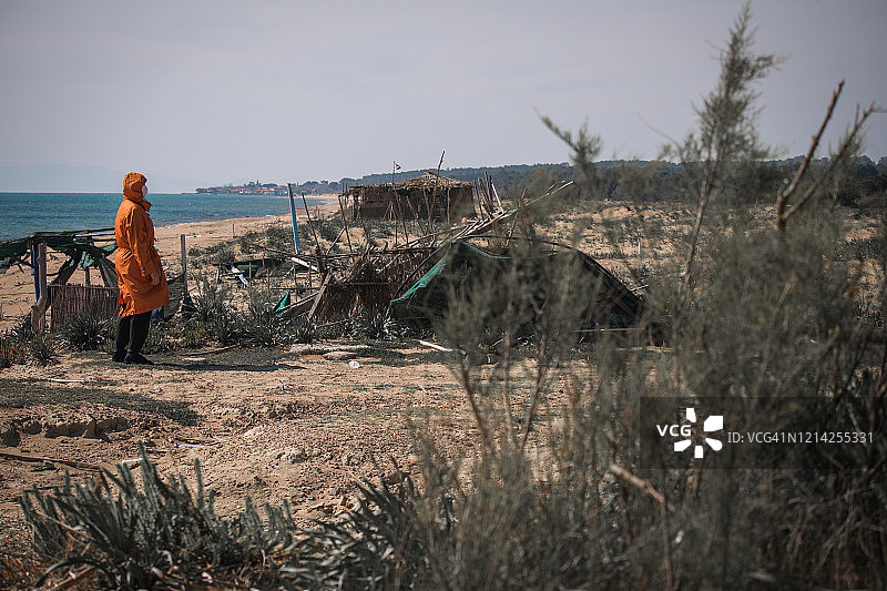 疫情期间希腊海滩上戴口罩的孤独女孩图片素材