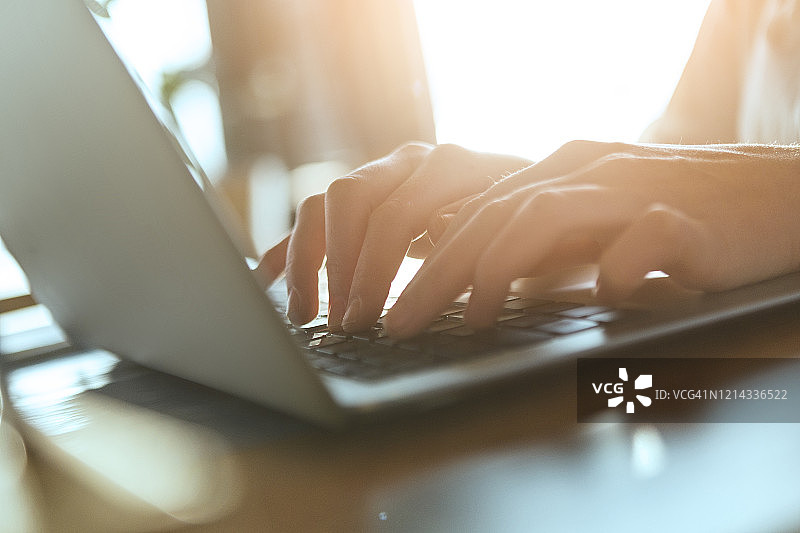 年轻女子正在用笔记本电脑打字图片素材