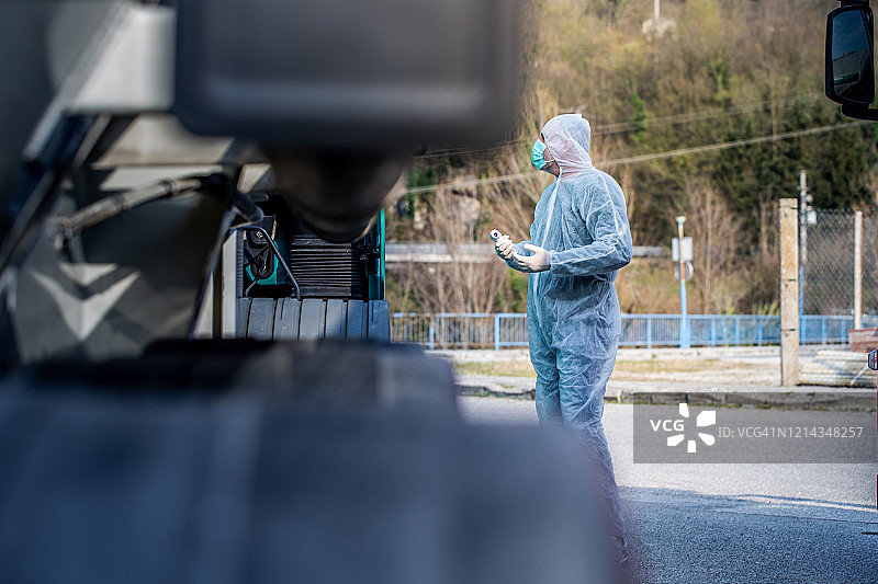 新冠疫情期间医护人员在边境管制站用红外测温仪检测司机体温图片素材