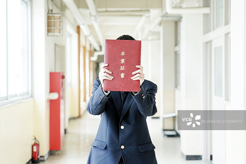 高中生在学校走廊里拿着文凭图片素材