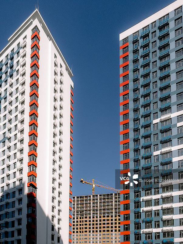 两座现代摩天大楼之间的建筑起重机图片素材