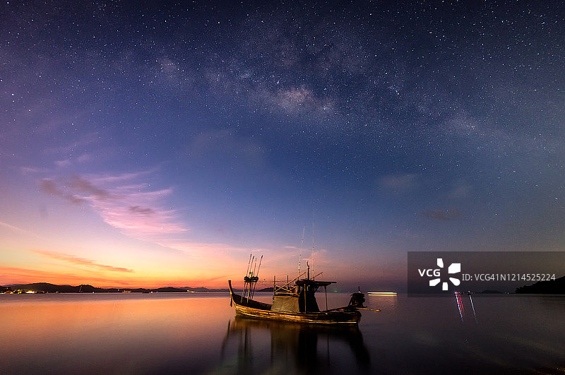 美丽的日出和银河，普吉岛Ao Por的孤独长尾船图片素材