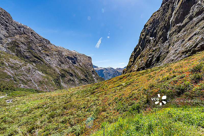 米尔福德峡湾的草甸和靠近荷马隧道的悬崖瀑布，新西兰南岛图片素材