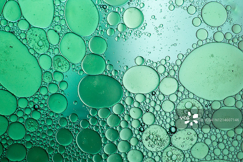 绿色灯光下的水面漂浮油渍抽象图案图片素材