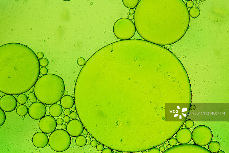 绿色灯光下的水面漂浮油渍抽象图案图片素材