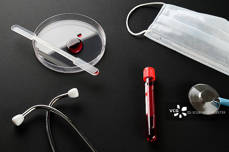 玻璃培养皿中的一滴血、医学研究样本试管、听诊器和医用防护口罩图片素材