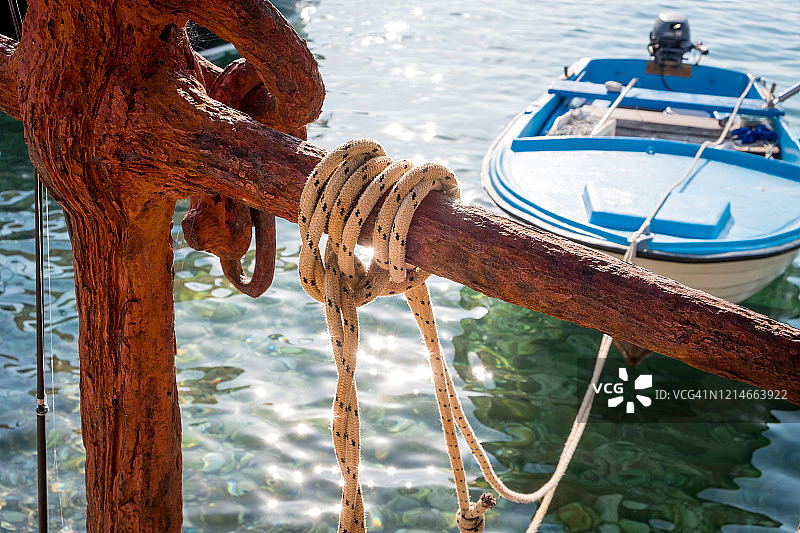 渔船绳索特写，背景为黑山的海、山和船只图片素材
