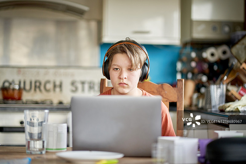 青少年男孩坐在餐桌旁图片素材