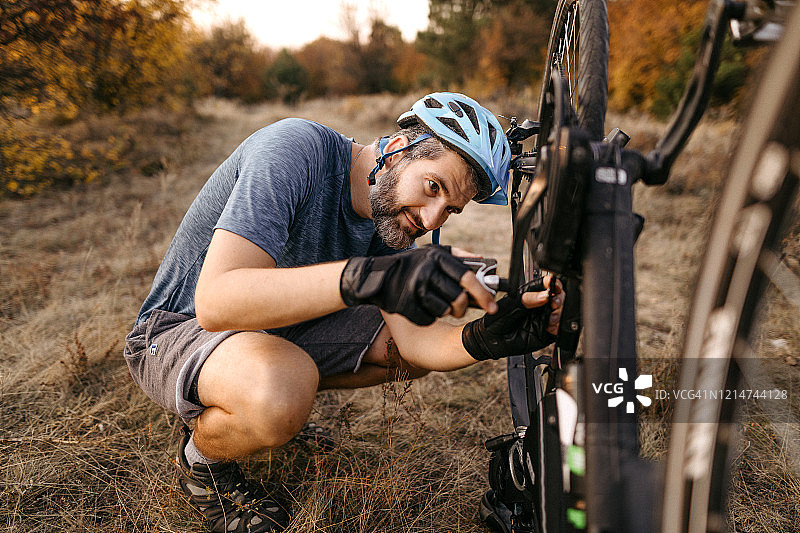 修理损坏的自行车的山地自行车骑行者图片素材