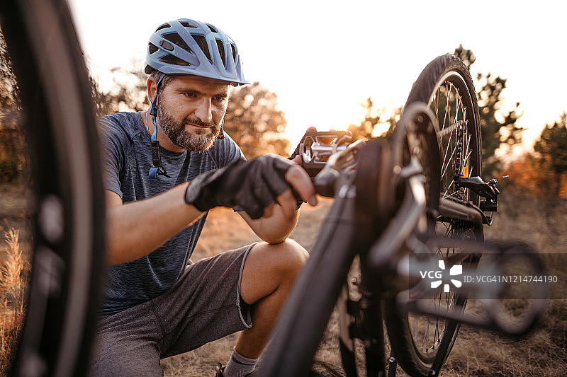修理损坏的自行车的山地自行车骑行者图片素材