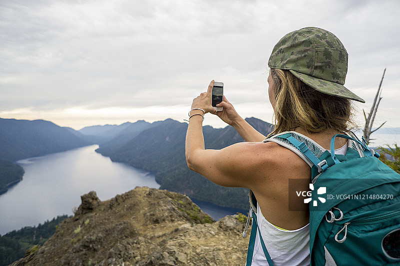 女人在奥林匹克国家公园徒步旅行时用手机拍照图片素材