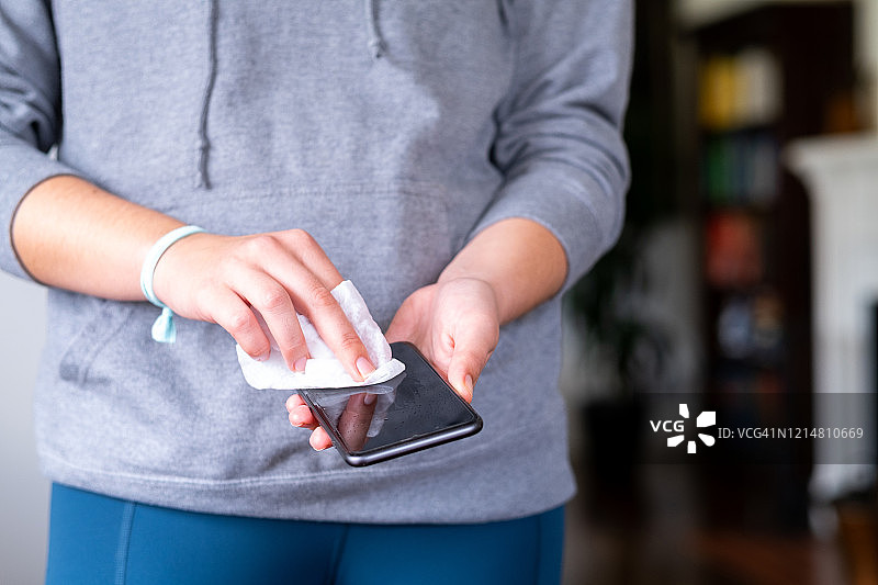 女人用一次性湿巾消毒智能手机图片素材