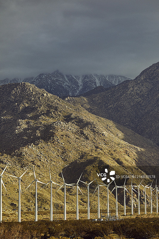 壮丽天空山脉下的可再生可持续风力发电厂图片素材