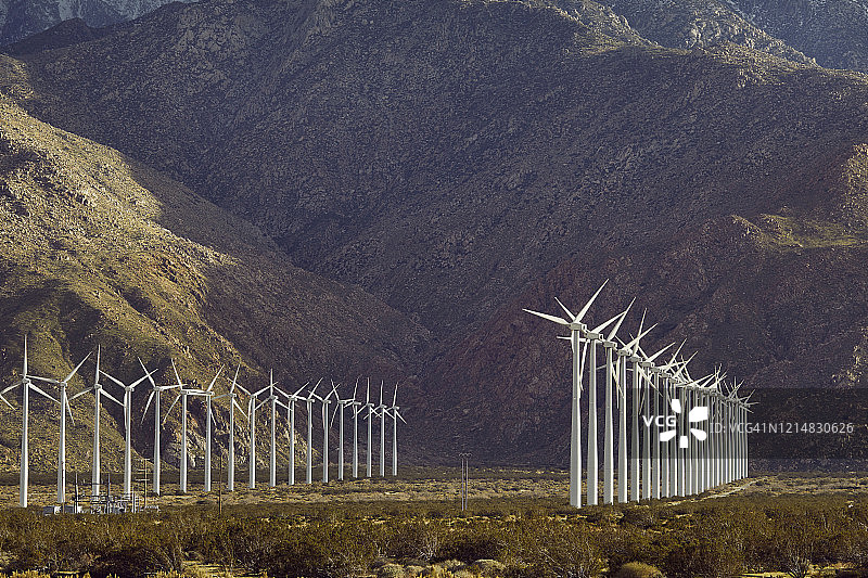 壮丽天空山脉下的可再生可持续风力发电厂图片素材