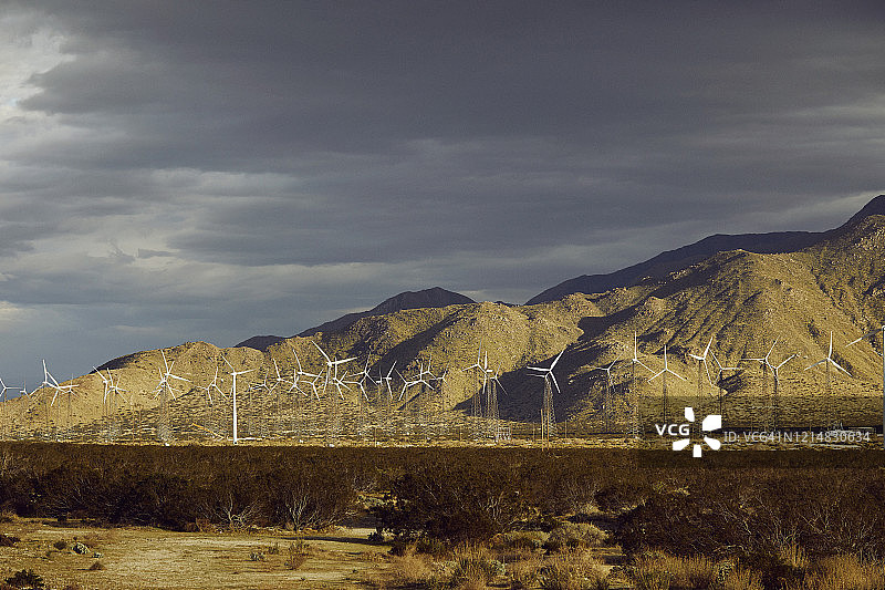 壮丽天空山脉下的可再生可持续风力发电厂图片素材