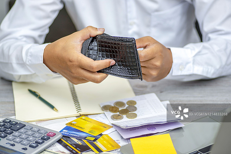 手持空钱包寻找金钱的贫困亚洲男人，面临破产问题图片素材