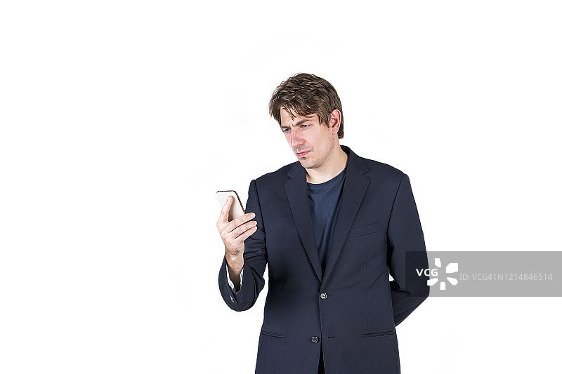 身穿商务套装的严肃男士使用手机，白色背景，留有复制空间和模型图片素材