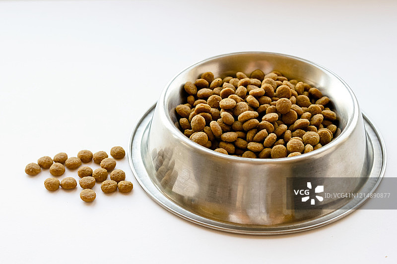 白色背景上金属碗里的猫狗粮图片素材