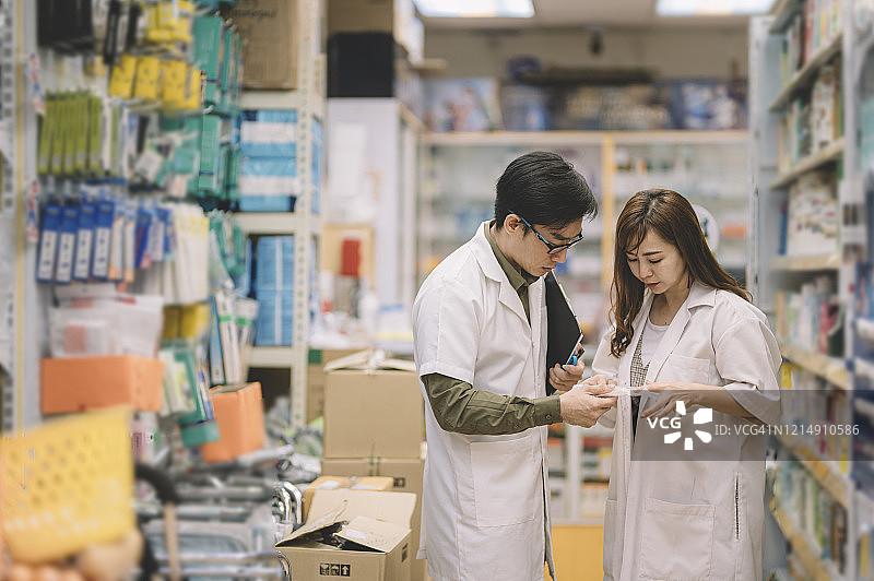 2名亚洲华人药剂师在药房商店进行讨论图片素材