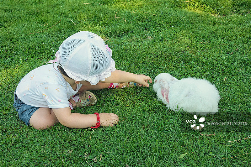 小女孩在罗马尼亚玩复活节彩蛋和兔子图片素材