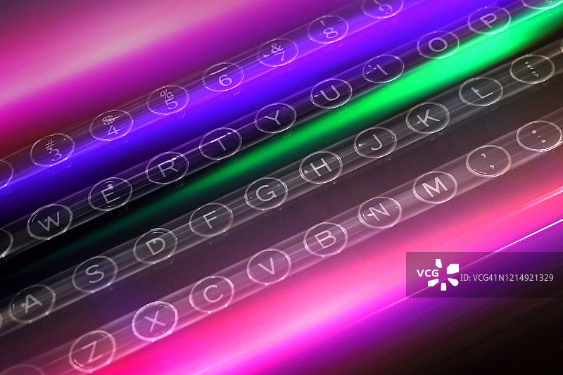 打字机按键上的彩色光迹图片素材