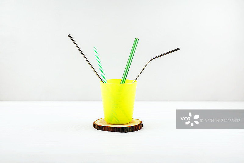 带不同吸管的黄色可重复使用杯子图片素材