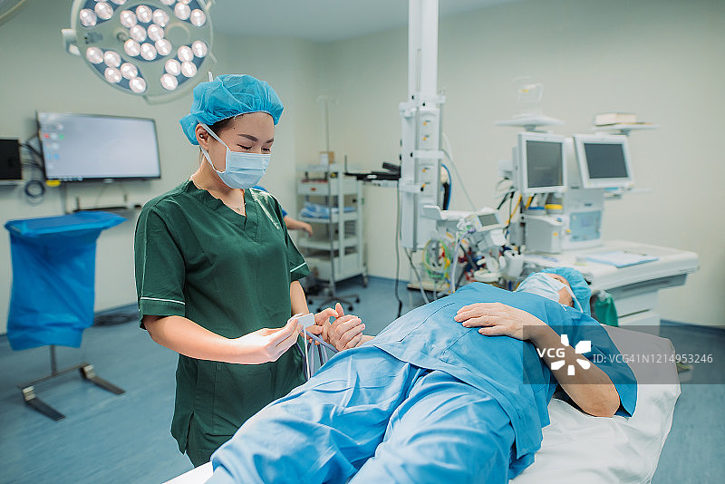 中国亚洲女麻醉师在医院为老年患者手术前戴上脉搏血氧仪图片素材