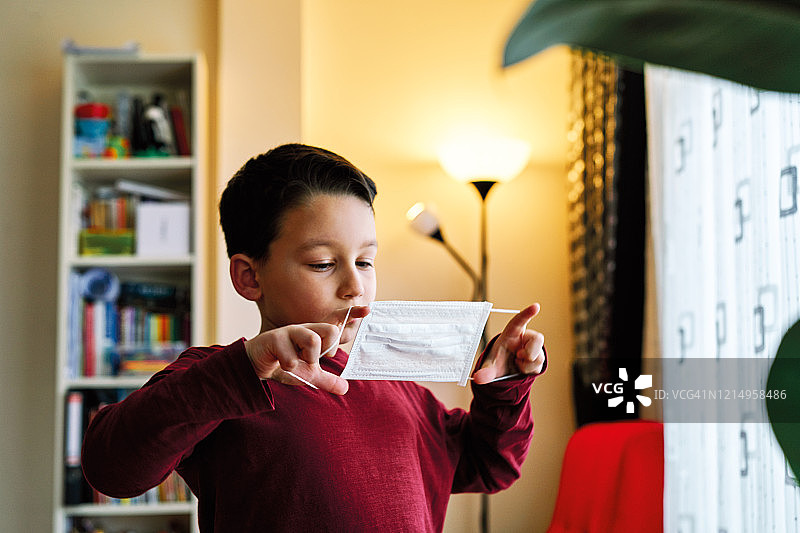 6-7岁可爱儿童居家进行社交隔离，为了预防冠状病毒感到无聊图片素材