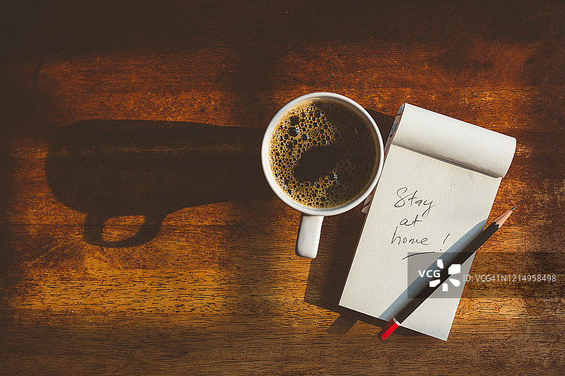 木纹桌上的居家隔离便签和黑咖啡图片素材