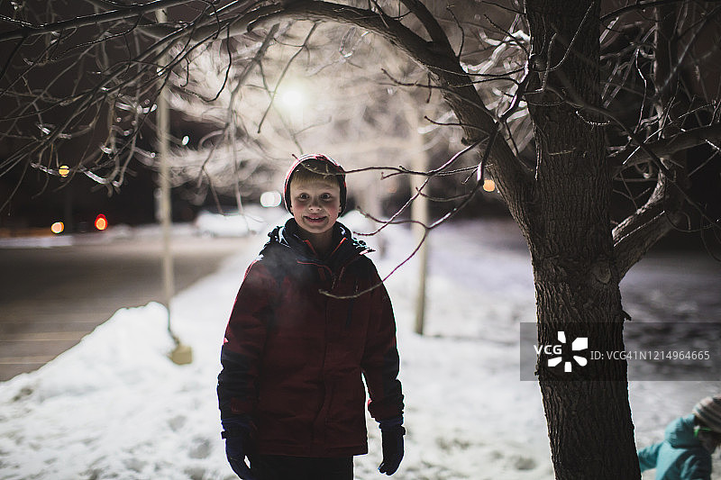 夜晚在雪中的男孩图片素材