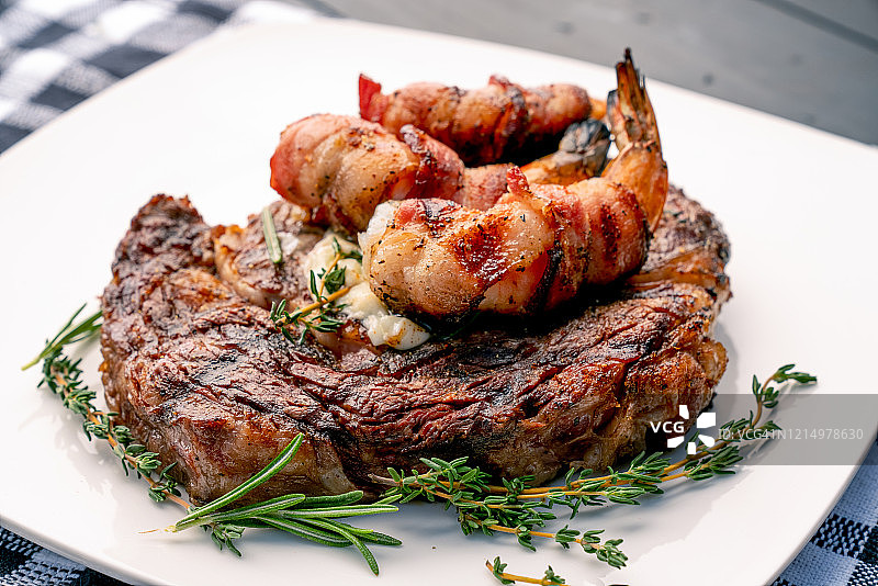 百里香迷迭香烤肋眼牛排配培根卷虾图片素材