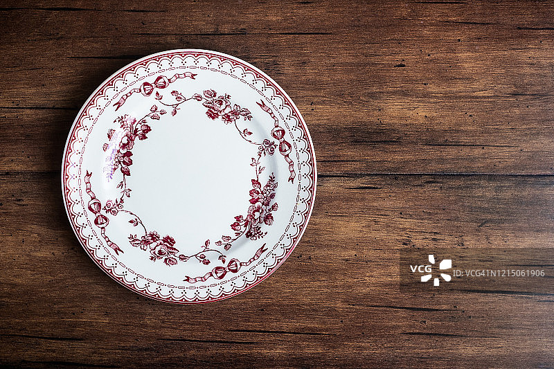 旧棕色木背景上带花纹的空盘俯视图，有留白图片素材