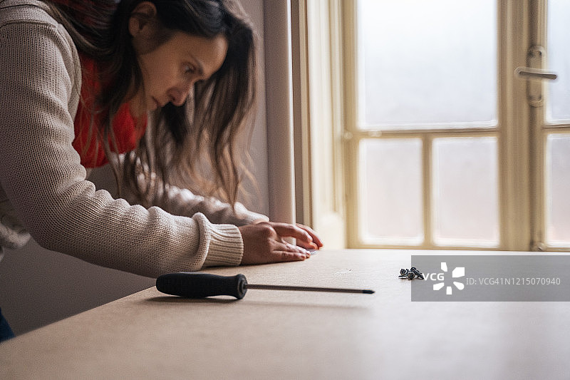 DIY年轻女人组装家具，家居改造图片素材