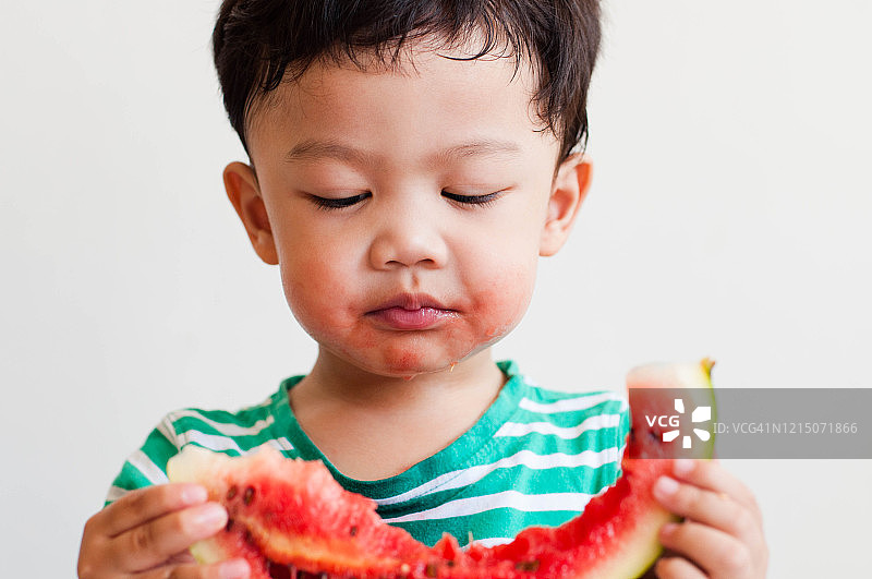 一名东南亚男童正在吃西瓜图片素材