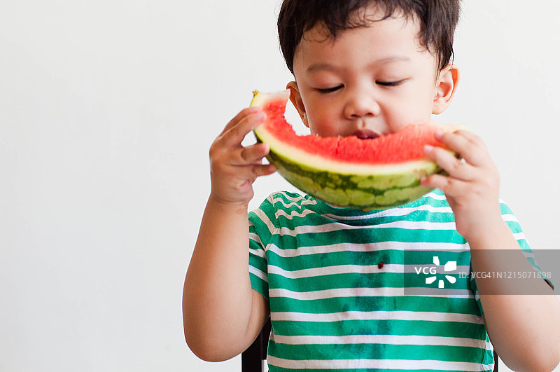一名东南亚男童正在吃西瓜图片素材