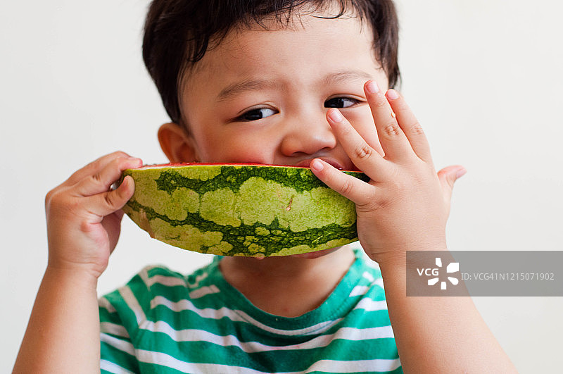 一名东南亚男童正在吃西瓜图片素材