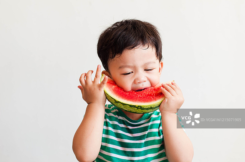 一名东南亚男童正在吃西瓜图片素材