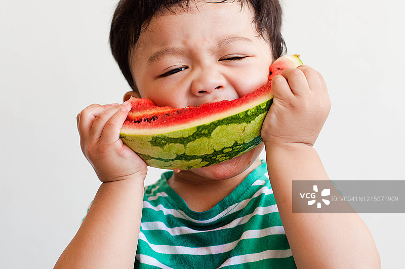 一名东南亚男童正在吃西瓜图片素材