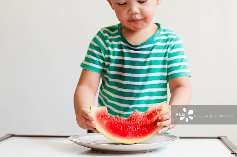 一名东南亚男童正在吃西瓜图片素材