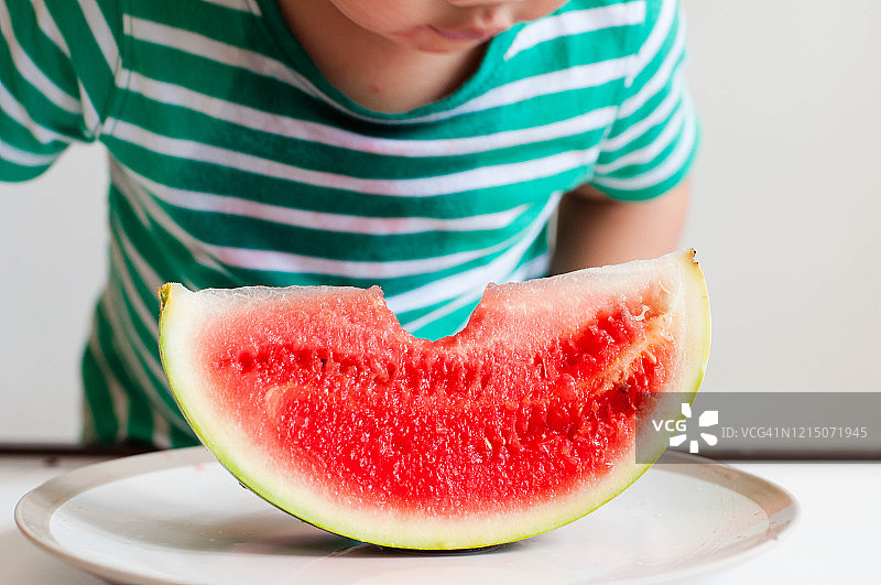 一名东南亚男童正在吃西瓜图片素材