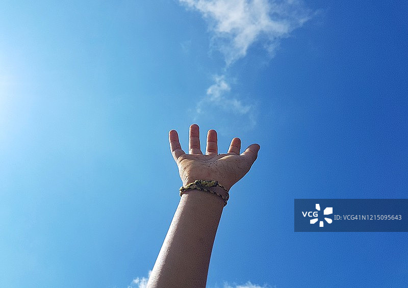 儿童在晴朗蓝天下做手势图片素材